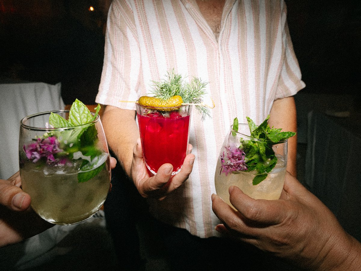 Evening bar setup with a large floral arrangement and cocktail menu cards