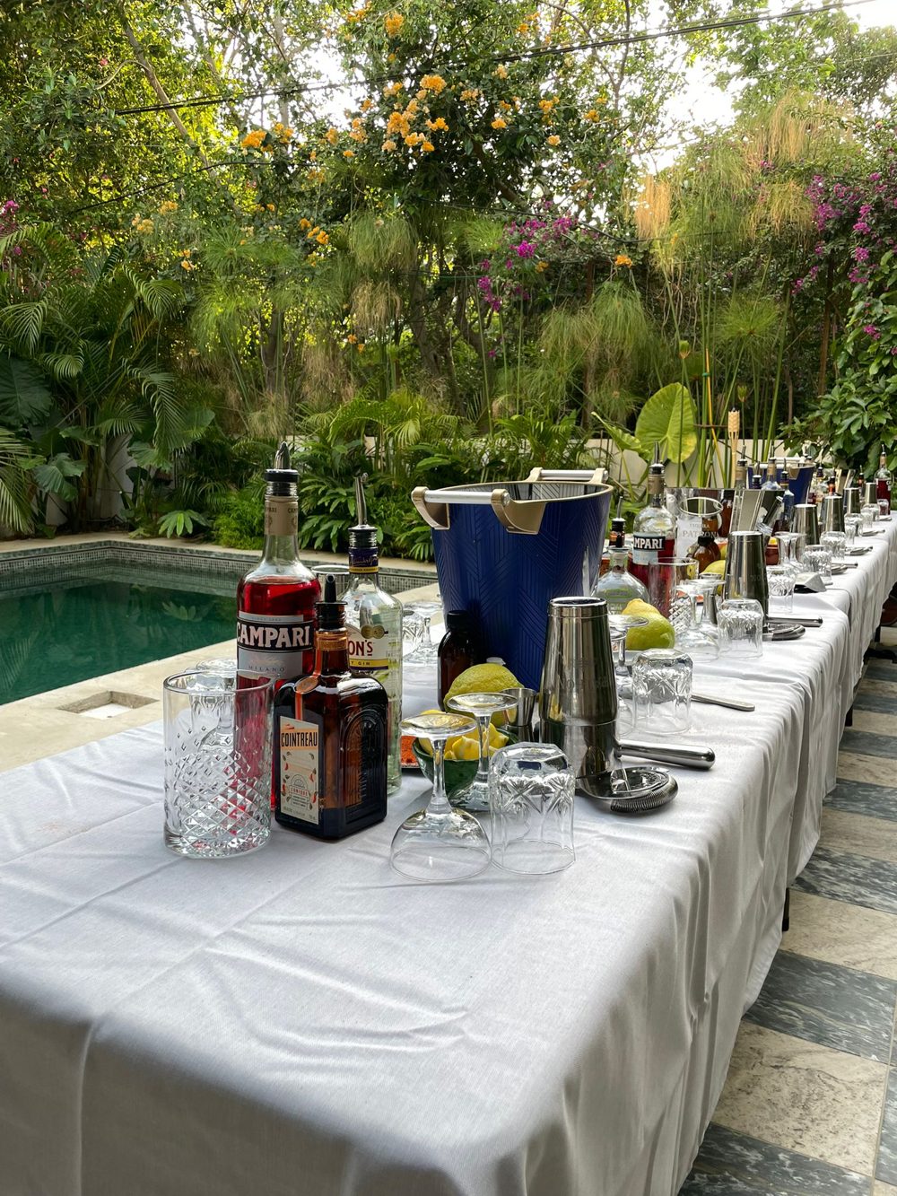 Cocktail workshop stations set up on a long table in a private garden