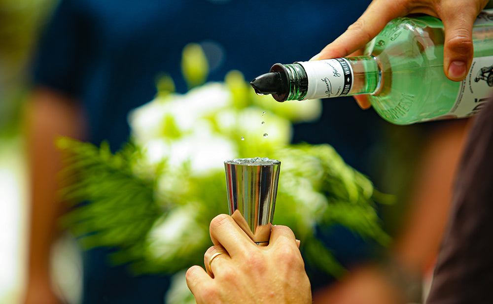 Measuring gin into a jigger during a cocktail workshop